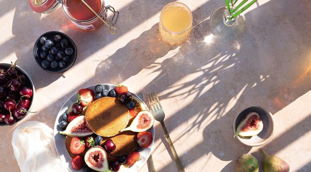 A healthy breakfast spread that includes blueberries, strawberries, figs, cherries and more.